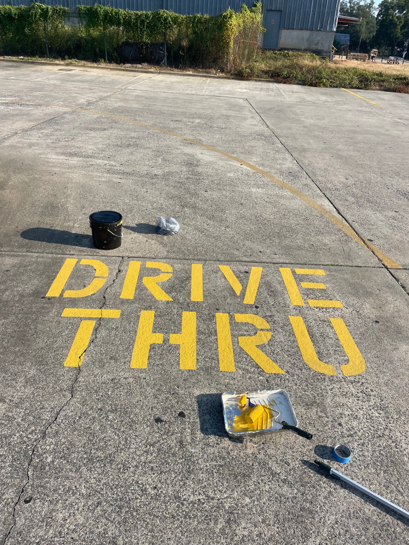 Fresh yellow DRIVE THRU lettering on concrete